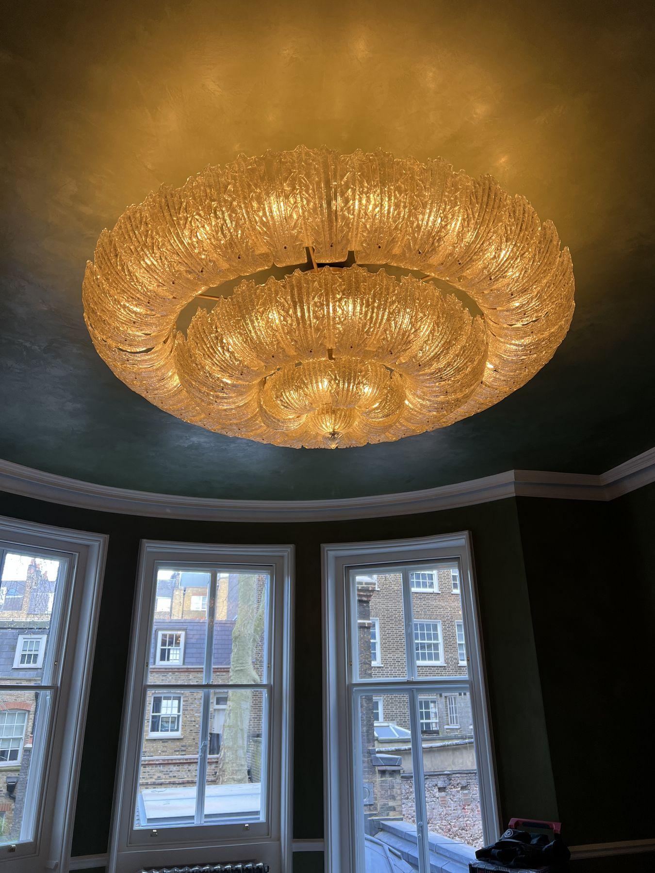 Murano glass leaf chandelier, lit, in a drawing room with bay windows