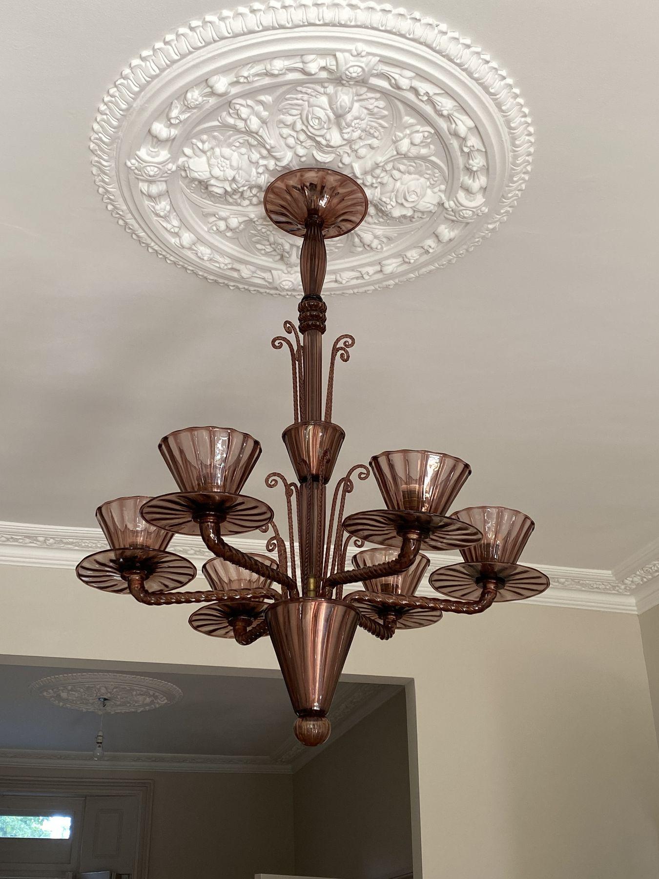 Amethyst glass chandelier below a plaster ceiling rose