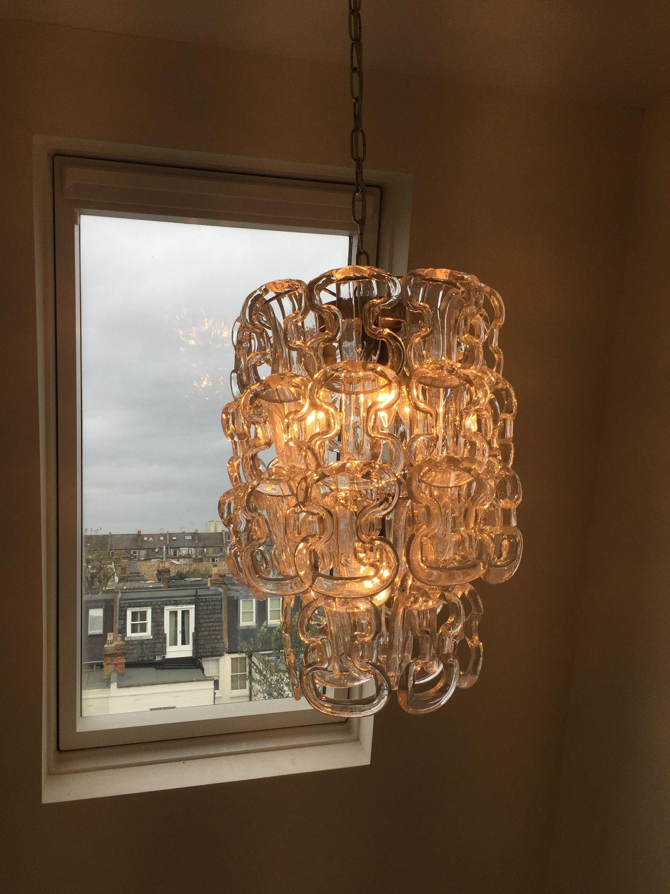 Glass link chandelier glowing in a window