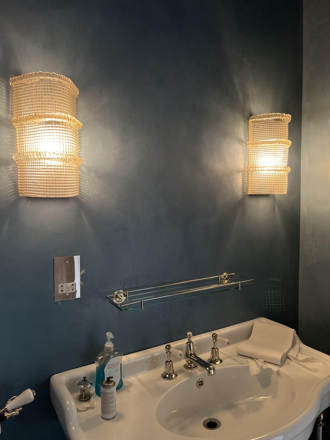 Pair of textured glass wall lights in a dark bathroom